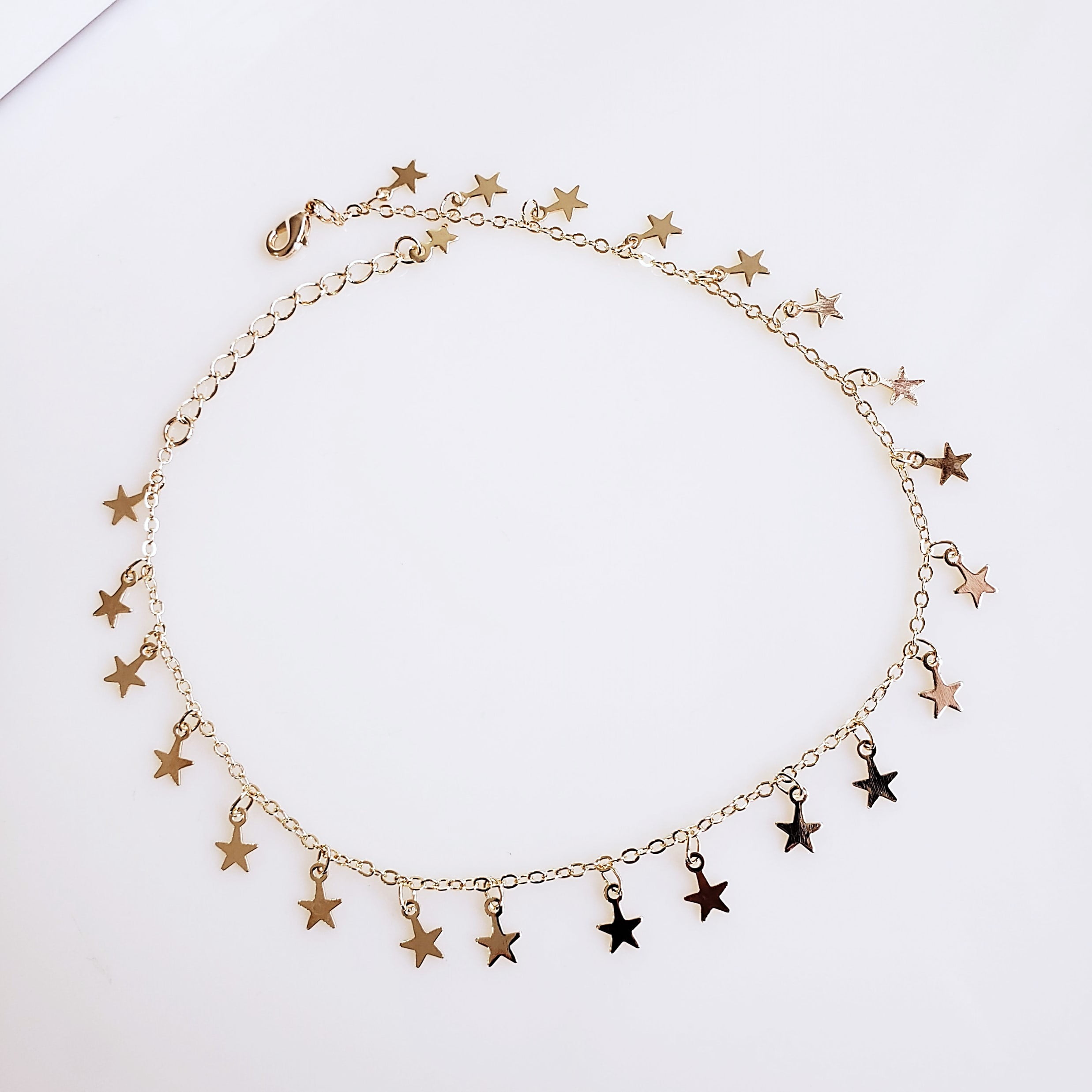 Tornozeleira com pingentinhos estrelas - banhado a ouro